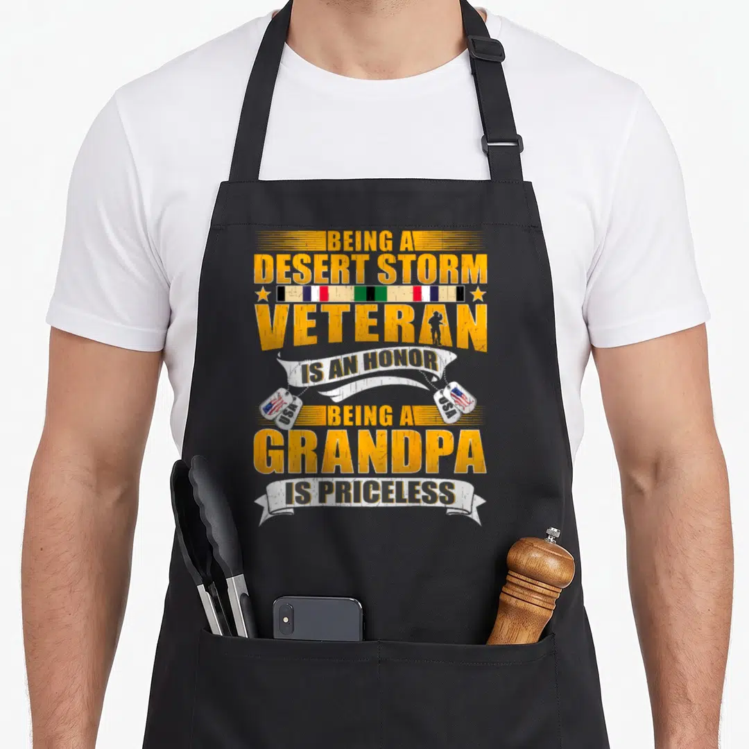 Storm grandpa apron - Distressed yellow text with military ribbons, soldier silhouette, and USA flag dog tags reading — shown on a black cotton canvas apron against a white background