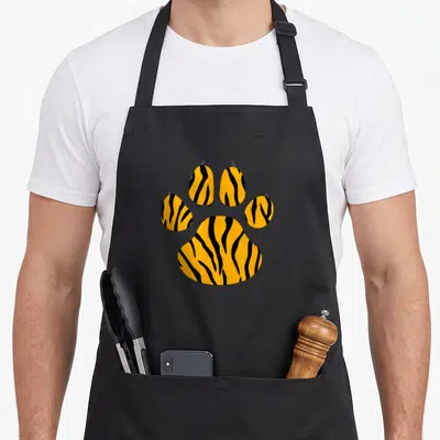 Tiger paw print apron - Orange and black tiger striped paw print graphic on canvas apron — shown on a black cotton canvas apron against a white background
