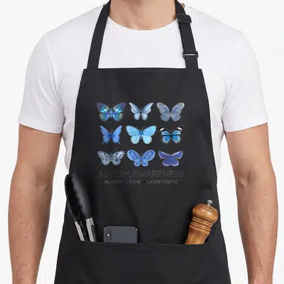 Butterfly april apron - Nine blue butterflies in a grid above Autism Awareness text — shown on a black cotton canvas apron against a white background