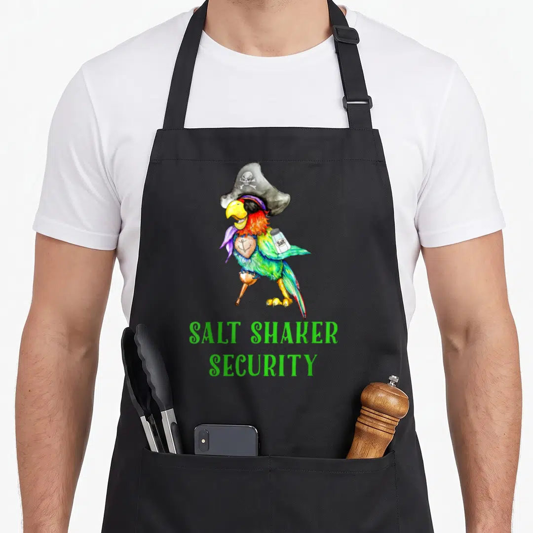 Salt parrot lady apron - Pirate parrot holding shaker above green SALT SHAKER SECURITY text — shown on a black cotton canvas apron against a white background