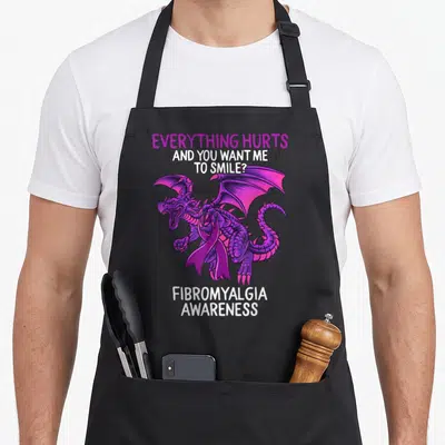 Fibromyalgia dragon apron - Purple dragon with ribbon and white text reading Everything Hurts Fibromyalgia Awareness — shown on a black cotton canvas apron against a white background