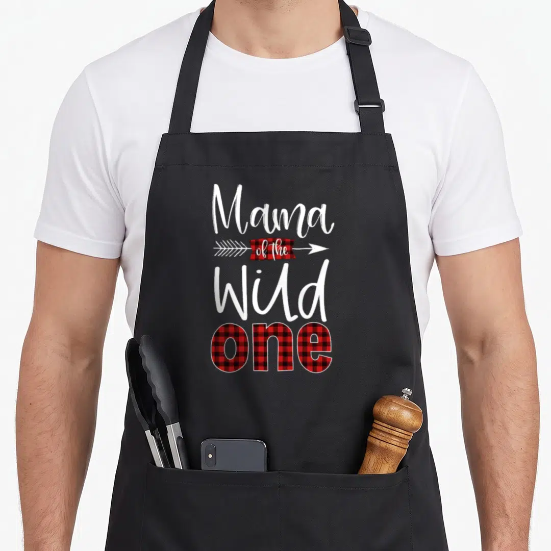 Lumberjack buffalo apron - Mama of the Wild One text with red black plaid arrow and retro font — shown on a black cotton canvas apron against a white background