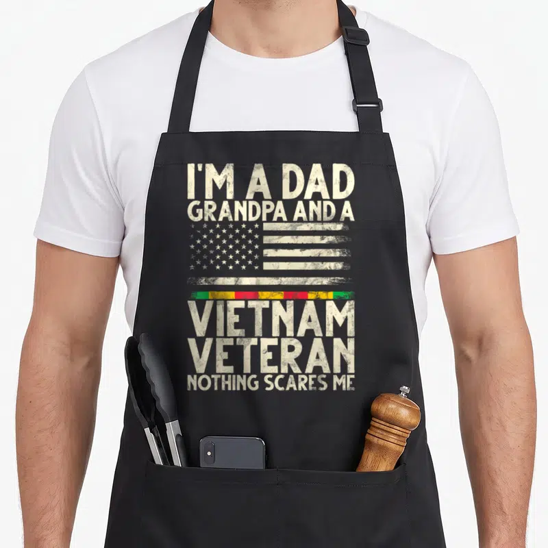 Vietnam grandpa apron - Distressed US flag and stacked text reading I'm a Dad Grandpa Vietnam Veteran Nothing Scares Me — shown on a black cotton canvas apron against a white background