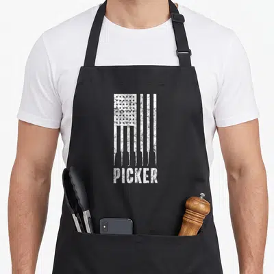 Lock american flag apron - Distressed white USA flag formed by lock pick shapes above the word PICKER — shown on a black cotton canvas apron against a white background