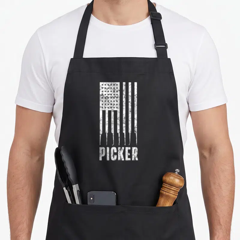 Lock american flag apron - Distressed white USA flag formed by lock pick shapes above the word PICKER — shown on a black cotton canvas apron against a white background