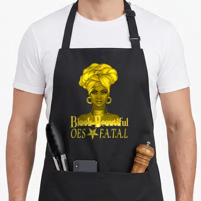 Diva ring apron - Yellow cartoon woman headwrap Black Beautiful OES F.A.T.A.L five point star text — shown on a black cotton canvas apron against a white background
