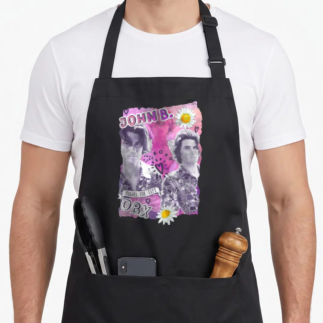 Outer valentine's day apron - Three male portraits with JOHN B POGUES FOR LIFE OBX text pink purple white flowers hearts — shown on a black cotton canvas apron against a white background