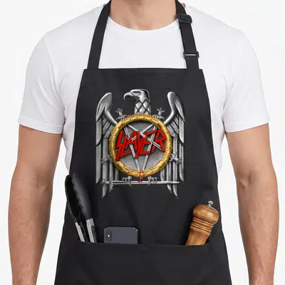 Funny slayer eagles grill apron - Silver eagle with spread wings holding a sword around a golden ring with red SLAYER — shown on a black cotton canvas apron against a white background