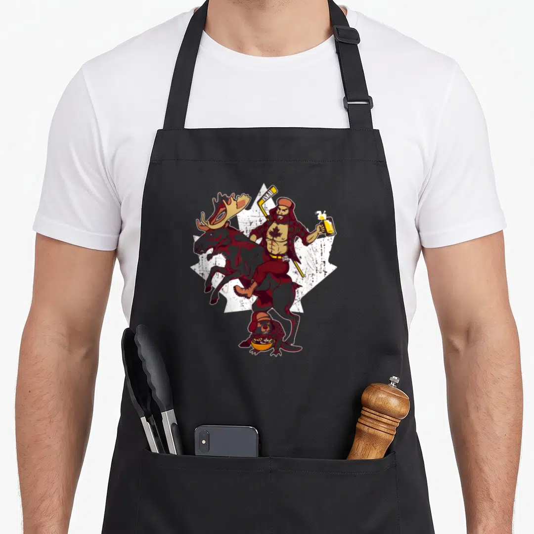 Epic pride apron - Man riding moose holding beer and hockey stick above beaver eating bowl on maple leaf — shown on a black cotton canvas apron against a white background