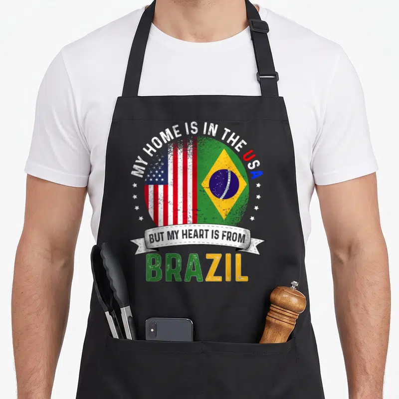 Brazilian patriot american flag apron - Split globe USA Brazil flags with My Home Is In The USA text and distressed — shown on a black cotton canvas apron against a white background