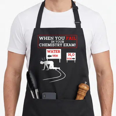Teacher pun chemistry apron - Kneeling figure between signs pointing to Water 9KM and H2O 50M under red bordered text — shown on a black cotton canvas apron against a white background