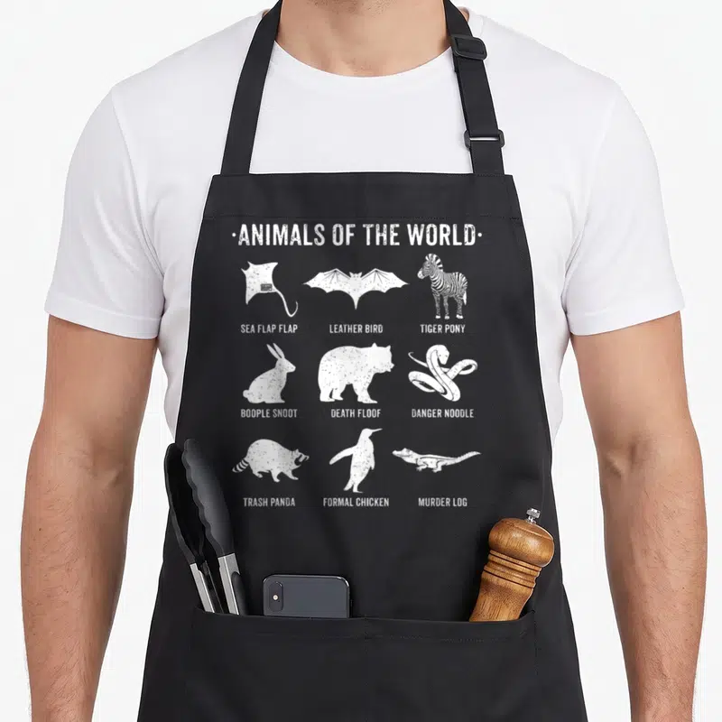 Simple animal apron - White silhouettes of animals with sarcastic text labels like Tiger Pony and Formal Chicken — shown on a black cotton canvas apron against a white background