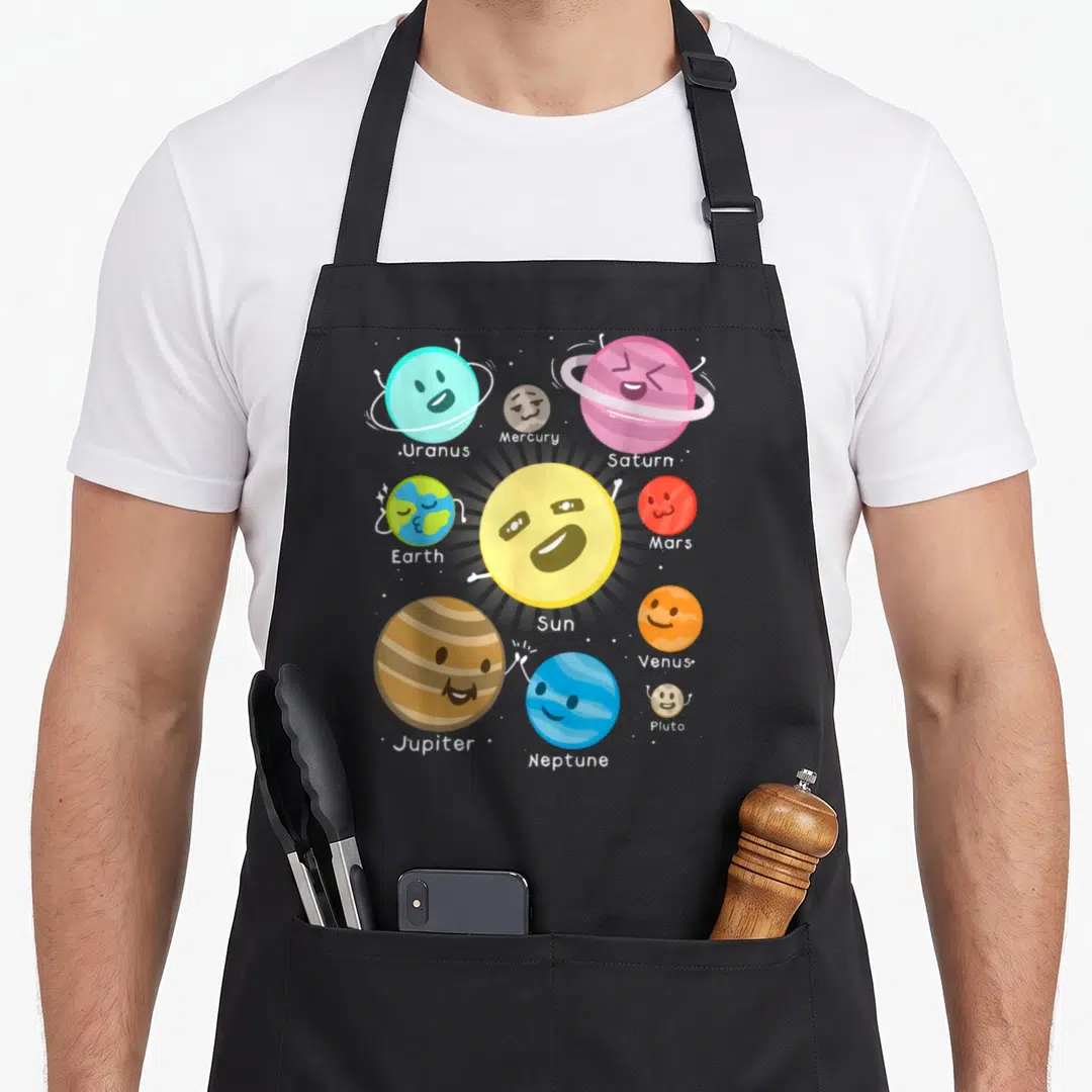 Outer space planets apron - Cartoon sun surrounded by nine labeled planets in yellow blue purple orange and red — shown on a black cotton canvas apron against a white background