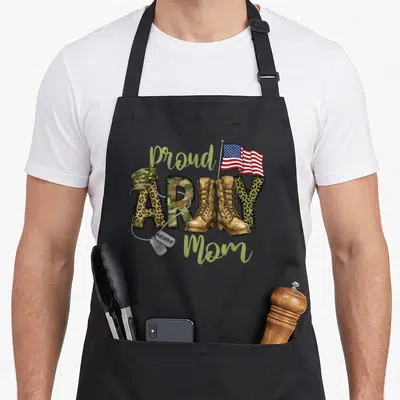 Military mother's day aprons - proud ARMY MY Mom with boots, flag, cap, dog tags in green tan red blue cartoon art — shown on a black cotton canvas apron against a white background