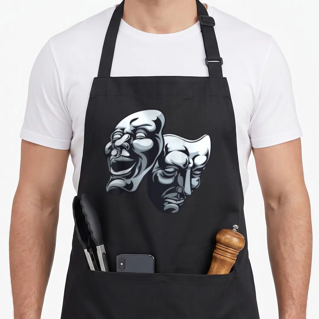 Mask theater apron - Two overlapping cartoon drama masks in white grey and black — shown on a black cotton canvas apron against a white background