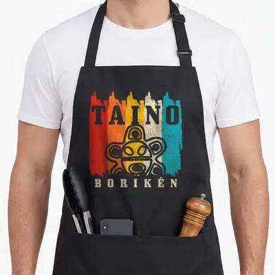 Boriken tandoori apron - TAINO BORIKEN petroglyph over red orange yellow beige blue brush strokes — shown on a black cotton canvas apron against a white background
