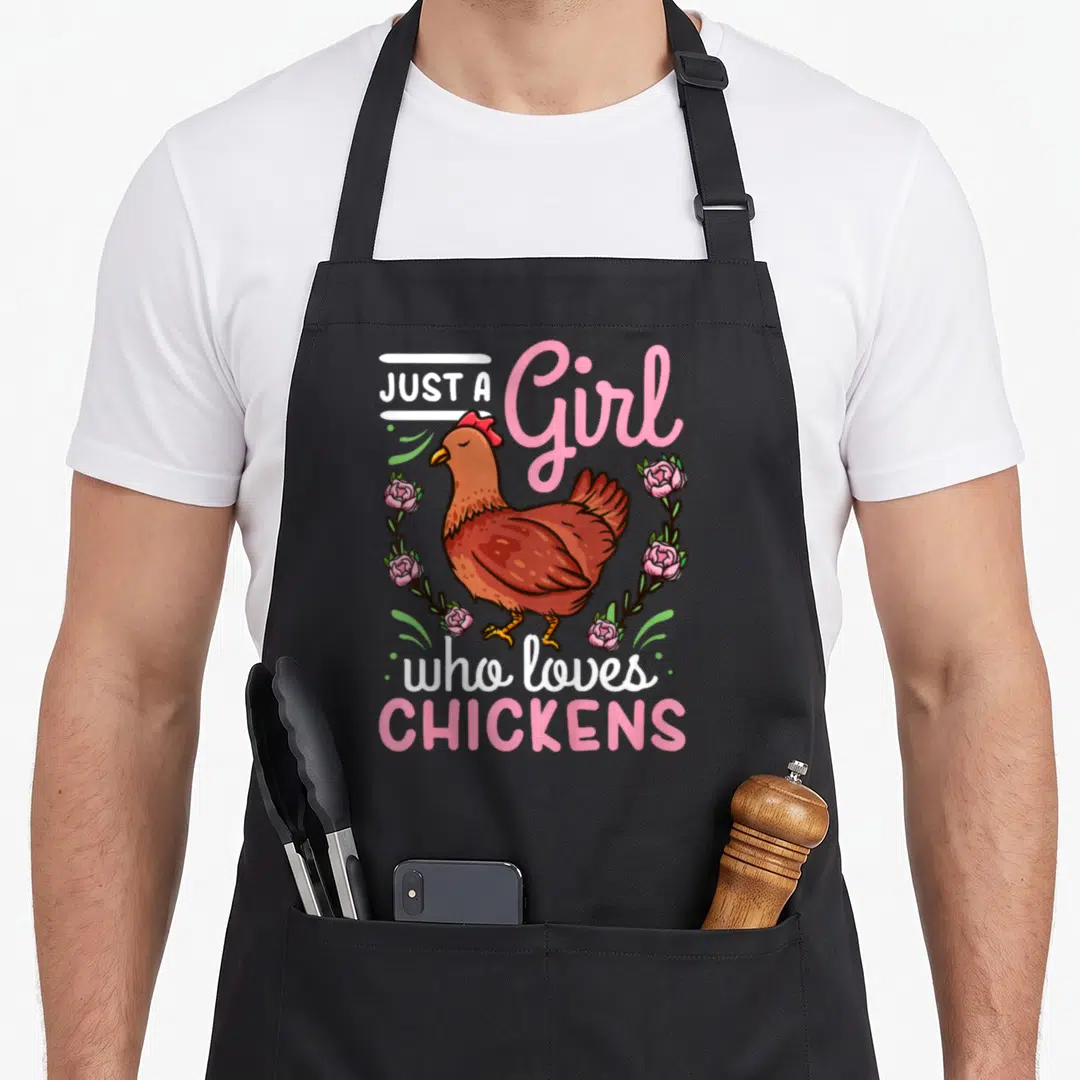 Cute animal chicken apron - Brown cartoon hen surrounded by pink roses and green leaves with white and pink text — shown on a black cotton canvas apron against a white background