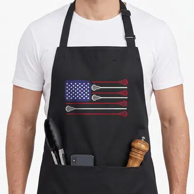 Flag lacrosse player apron - Stylized flag with red and white lacrosse stick stripes and blue canton with white dots — shown on a black cotton canvas apron against a white background