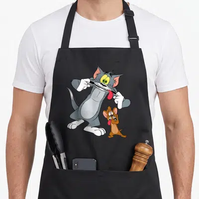 Hobby face apron - Grey cat and brown mouse cartoon pulling down lips to show red tongues — shown on a black cotton canvas apron against a white background