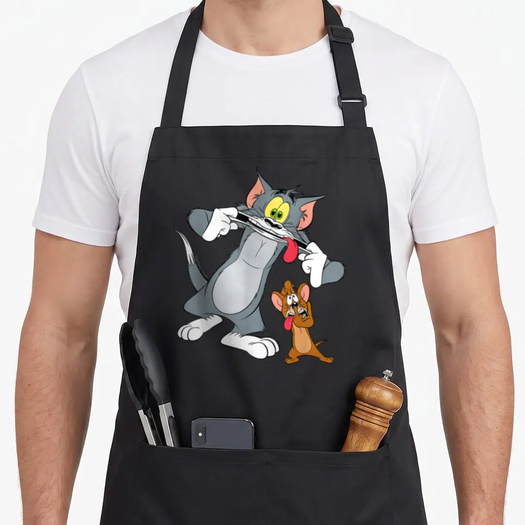 Hobby face apron - Grey cat and brown mouse cartoon pulling down lips to show red tongues — shown on a black cotton canvas apron against a white background