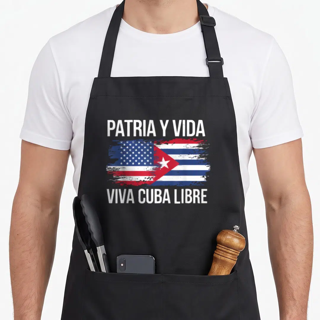 Country cuba american flag apron - Split US and Cuban flag with distressed paint and white text PATRIA Y VIDA VIVA CUBA — shown on a black cotton canvas apron against a white background