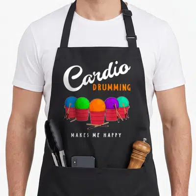 Cardio online squad apron - Five red buckets with colored balls and drumsticks under Cardio Drumming Makes Me Happy text — shown on a black cotton canvas apron against a white background