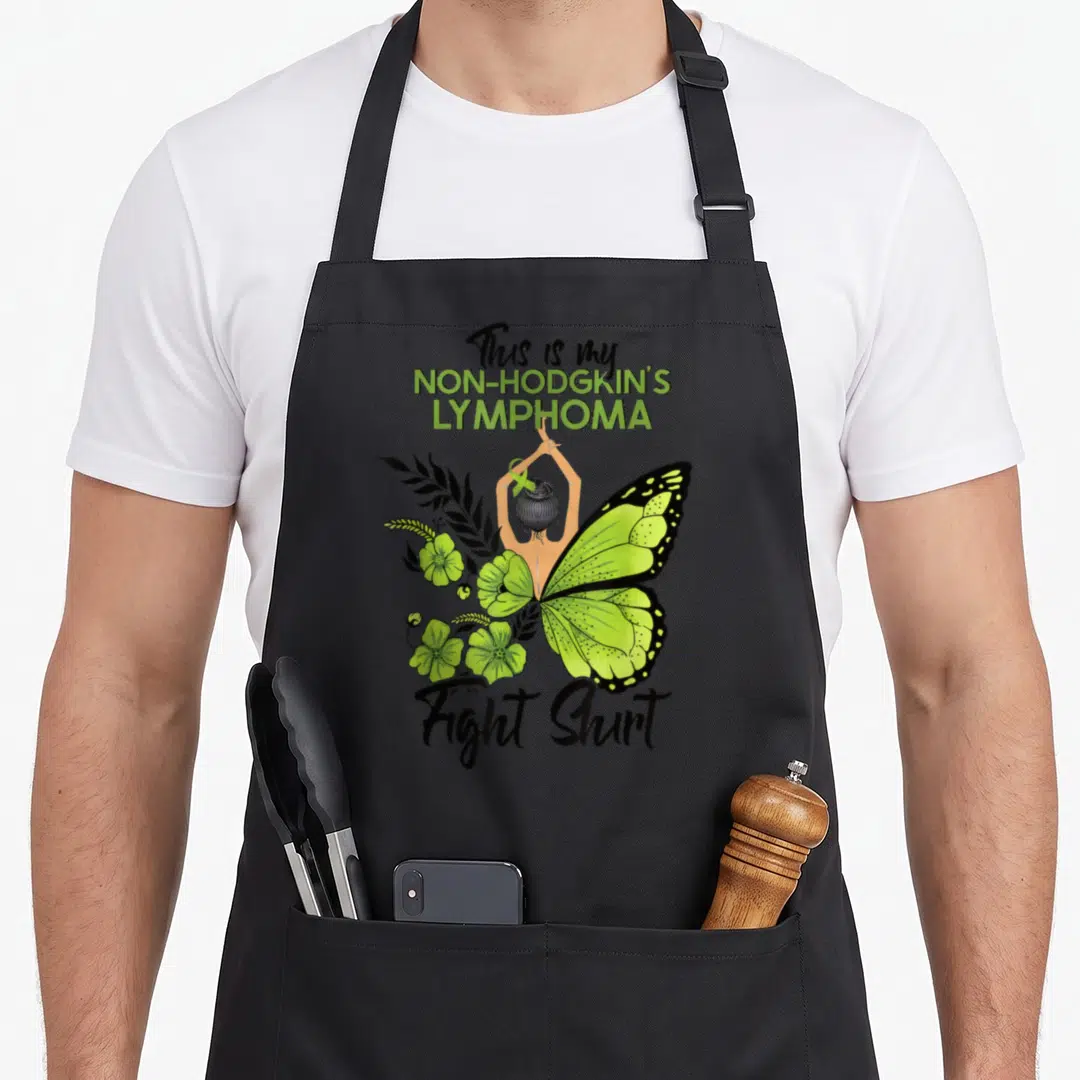 Non hodgkin ribbon apron - Woman back merging into lime green butterfly wing with flowers and awareness text — shown on a black cotton canvas apron against a white background