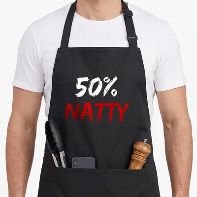 Percent joke apron - Distressed white 50% and red NATTY text stacked vertically — shown on a black cotton canvas apron against a white background