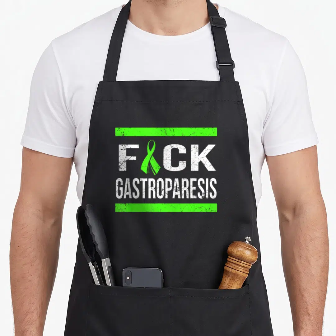 Support gastroparesis awareness apron - Green ribbon replaces U in FICK text between two green bars — shown on a black cotton canvas apron against a white background