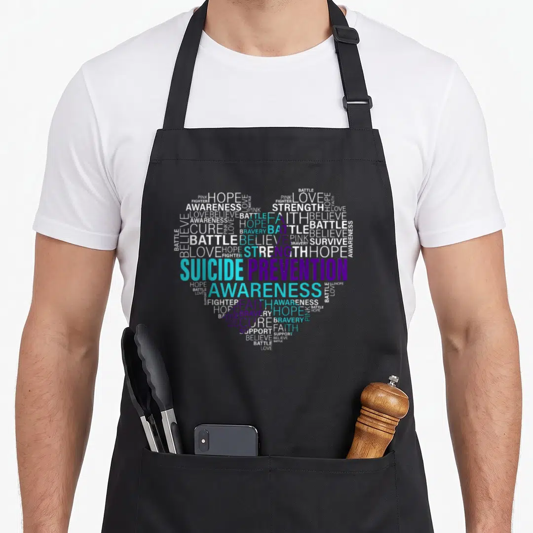 Suicide strong mom apron - Heart-shaped word cloud with suicide prevention awareness in teal purple white text — shown on a black cotton canvas apron against a white background