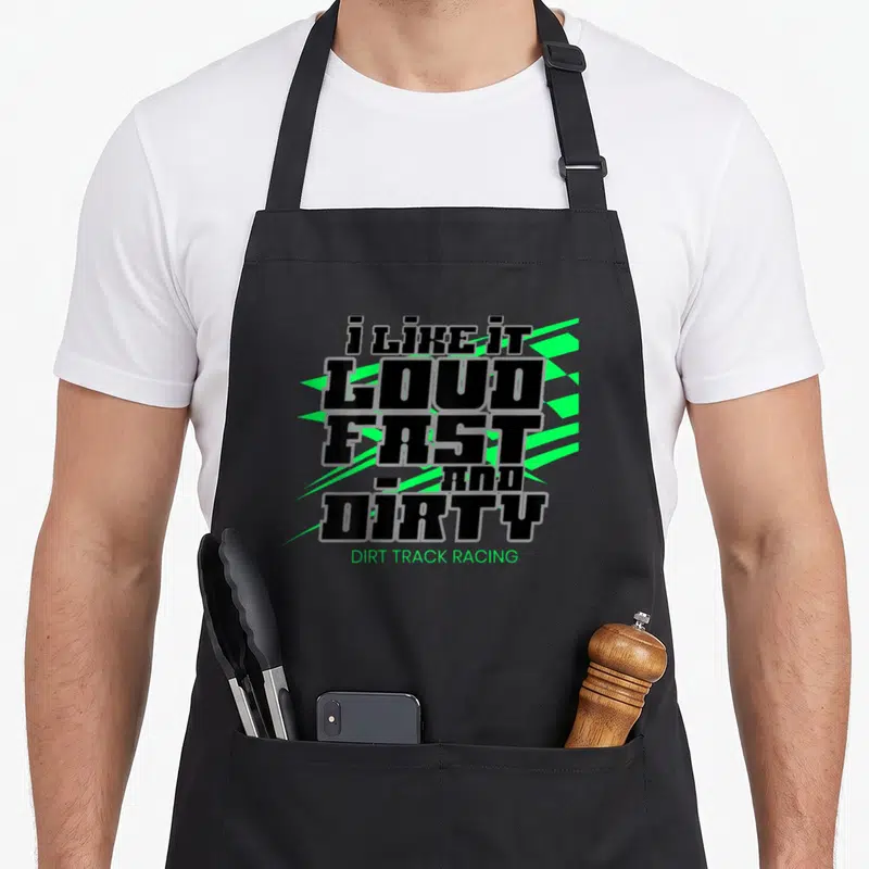 Modified track apron - i LIKE IT LOUD FAST AND DIRTY black text with neon green shards — shown on a black cotton canvas apron against a white background