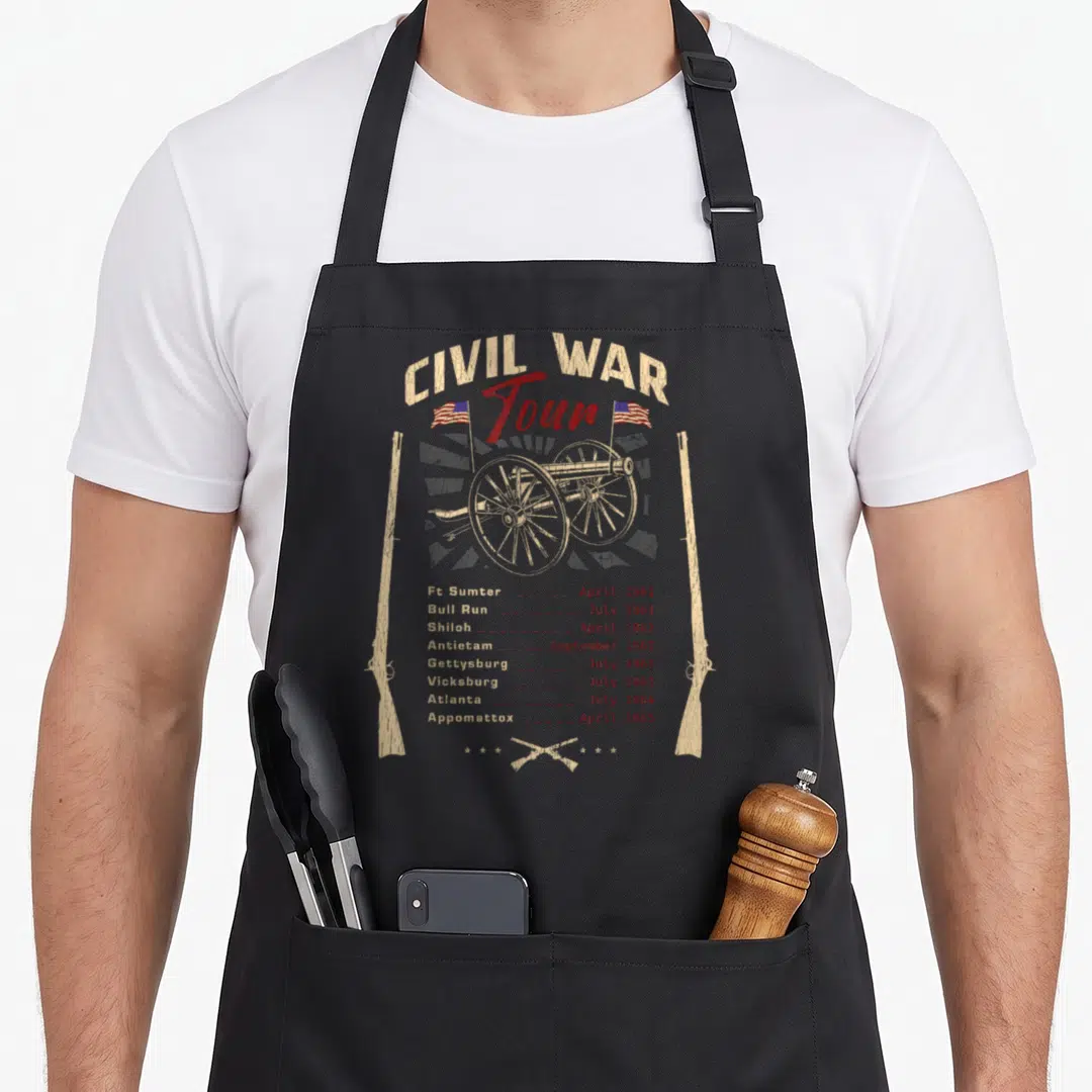 Tour civil war apron - Cannon and rifles with battle dates Ft Sumter to Appomattox in beige and red — shown on a black cotton canvas apron against a white background