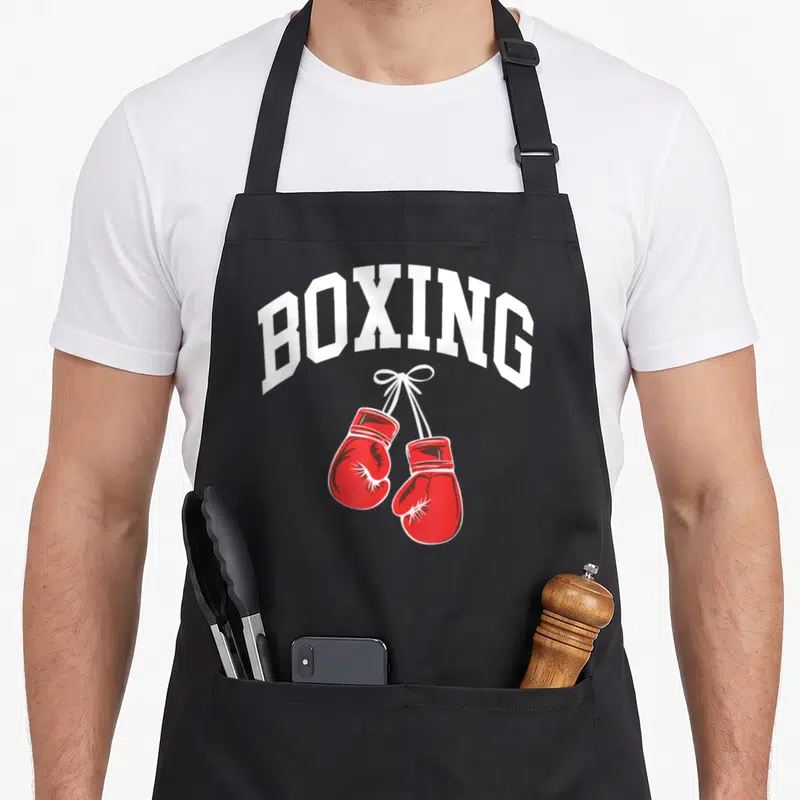 Boxing boxer gloves and apron - Arched white BOXING text above a pair of red boxing gloves hanging by laces — shown on a black cotton canvas apron against a white background
