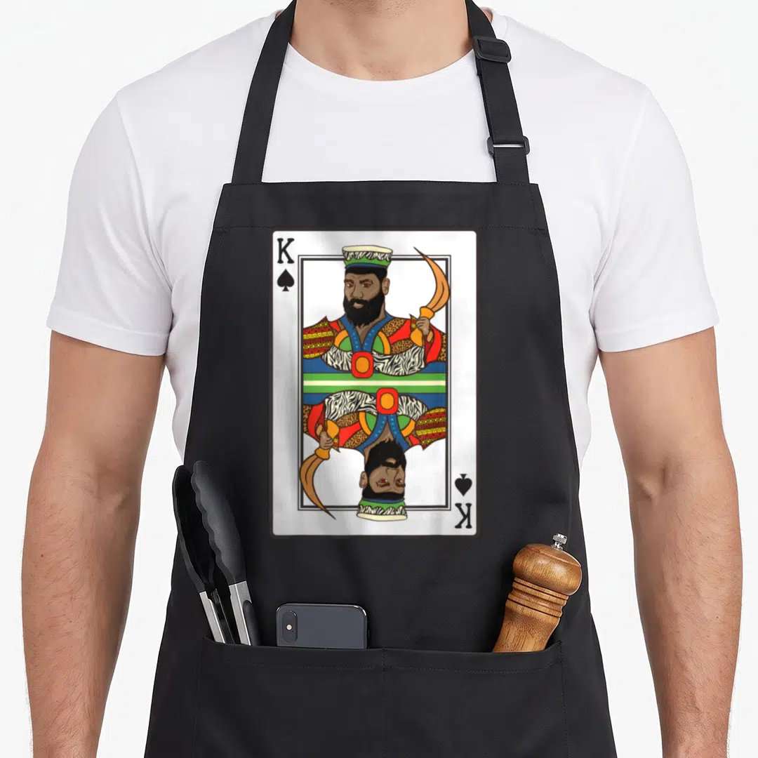 Spade african american aprons - Mirrored King of Spades playing card illustration in red, yellow, green, blue, and gold — shown on a black cotton canvas apron against a white background