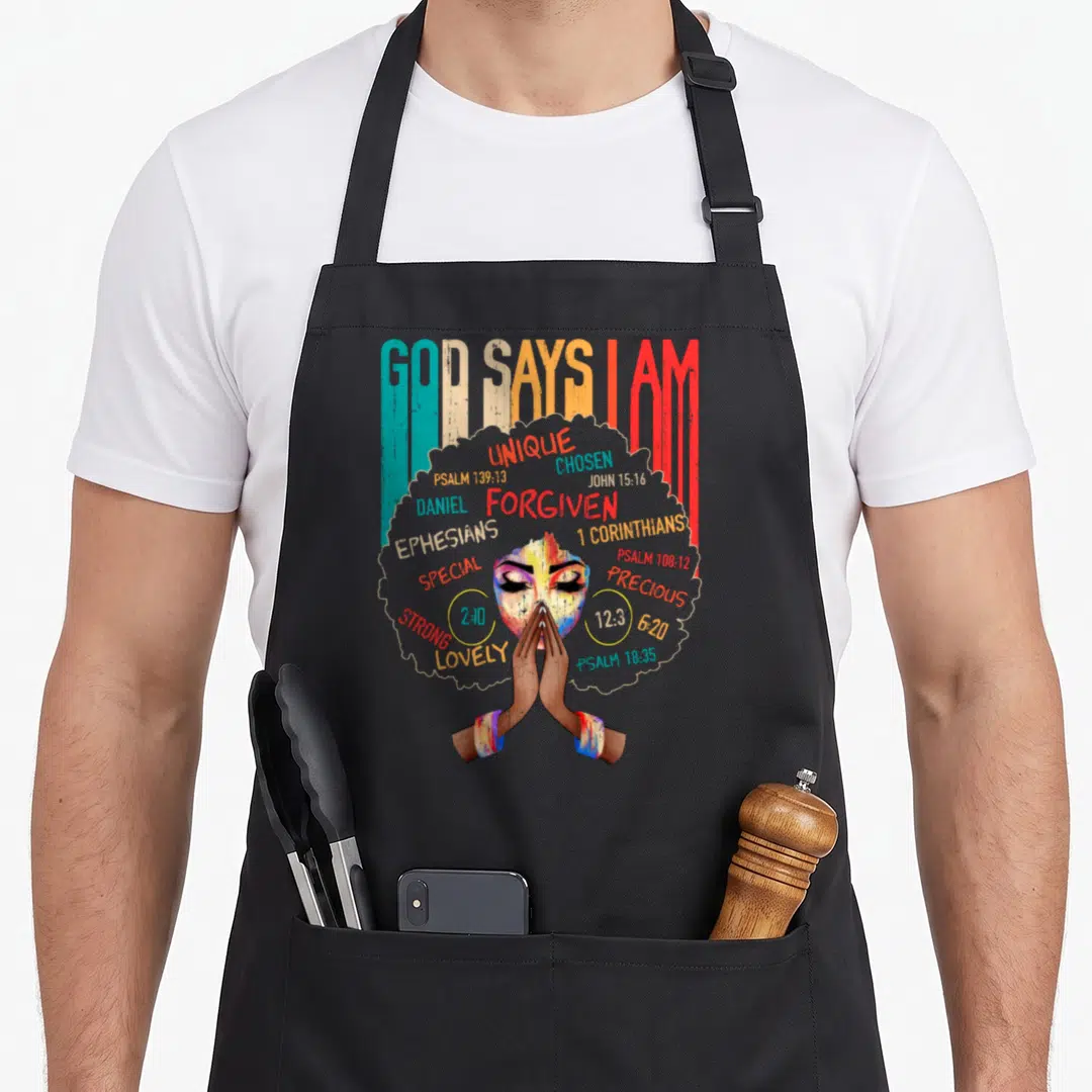 Month god says i am apron - Woman praying with afro filled with words UNIQUE CHOSEN FORGIVEN STRONG LOVELY PRECIOUS — shown on a black cotton canvas apron against a white background