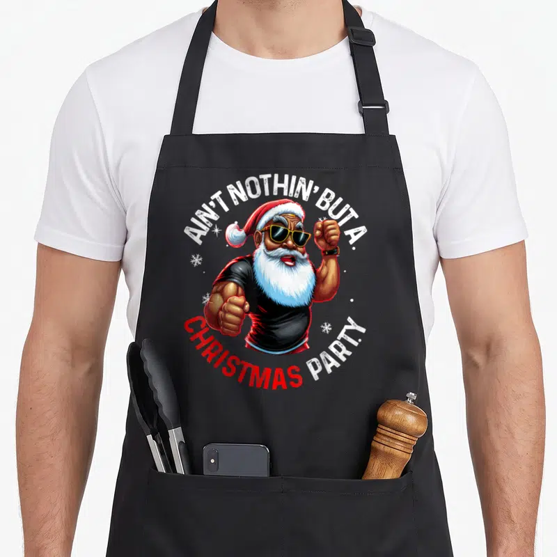 African santa claus apron - Cartoon Santa with sunglasses and AIN'T NOTHIN BUT A CHRISTMAS PARTY text — shown on a black cotton canvas apron against a white background