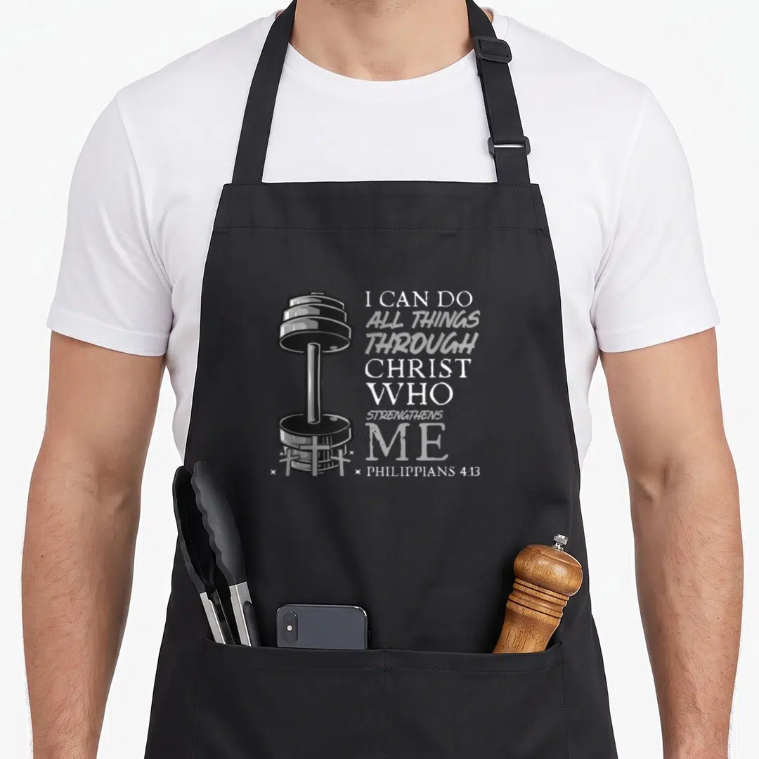 Weightlifter bible verse apron - Realistic dumbbell with three small crosses and stacked Philippians 4:13 text in grey — shown on a black cotton canvas apron against a white background