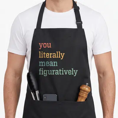 Literally english chef apron - Stacked red yellow teal and green text reading you literally mean figuratively — shown on a black cotton canvas apron against a white background