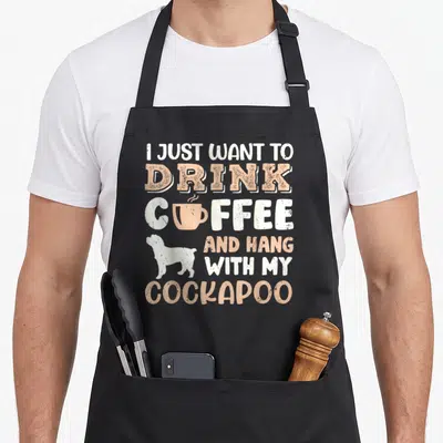 Drink cockapoo apron - Stacked I just want to drink coffee hang with my cockapoo text with cup and dog silhouette — shown on a black cotton canvas apron against a white background