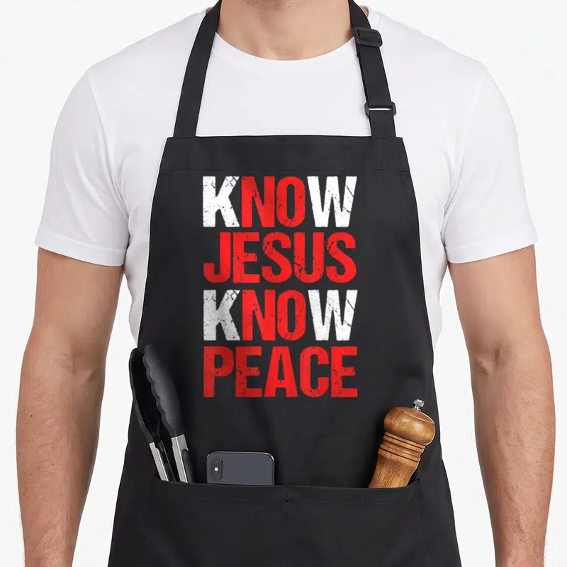 Peace christian apron - Stacked white and red distressed text reading Know Jesus Know Peace — shown on a black cotton canvas apron against a white background