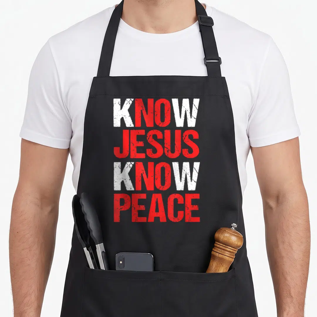 Peace christian apron - Stacked white and red distressed text reading Know Jesus Know Peace — shown on a black cotton canvas apron against a white background