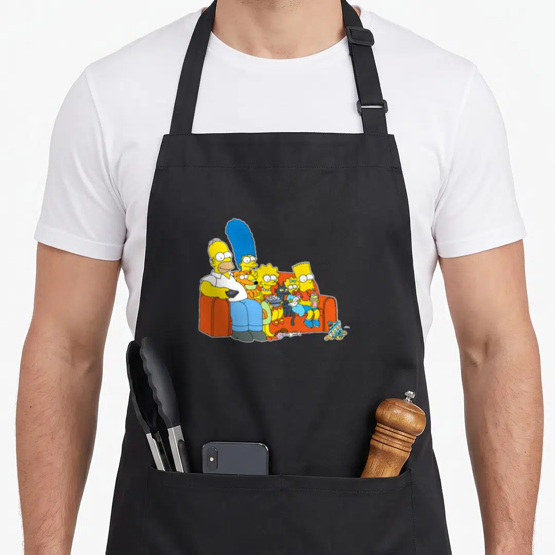 Marge couch apron - Simpson family seated on orange sofa in yellow blue orange cartoon art — shown on a black cotton canvas apron against a white background