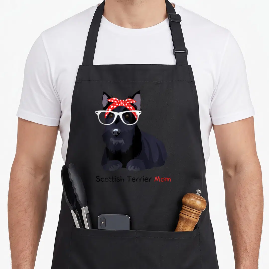 Scottie dog apron - Cartoon black Scottie dog with white glasses and red polka dot bandana — shown on a black cotton canvas apron against a white background