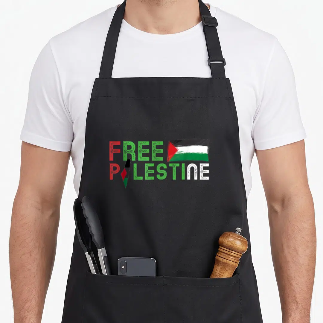 Flag arabic palestinian apron - FREE PALESTINE text with map replacing A and flag graphic in red green white black — shown on a black cotton canvas apron against a white background
