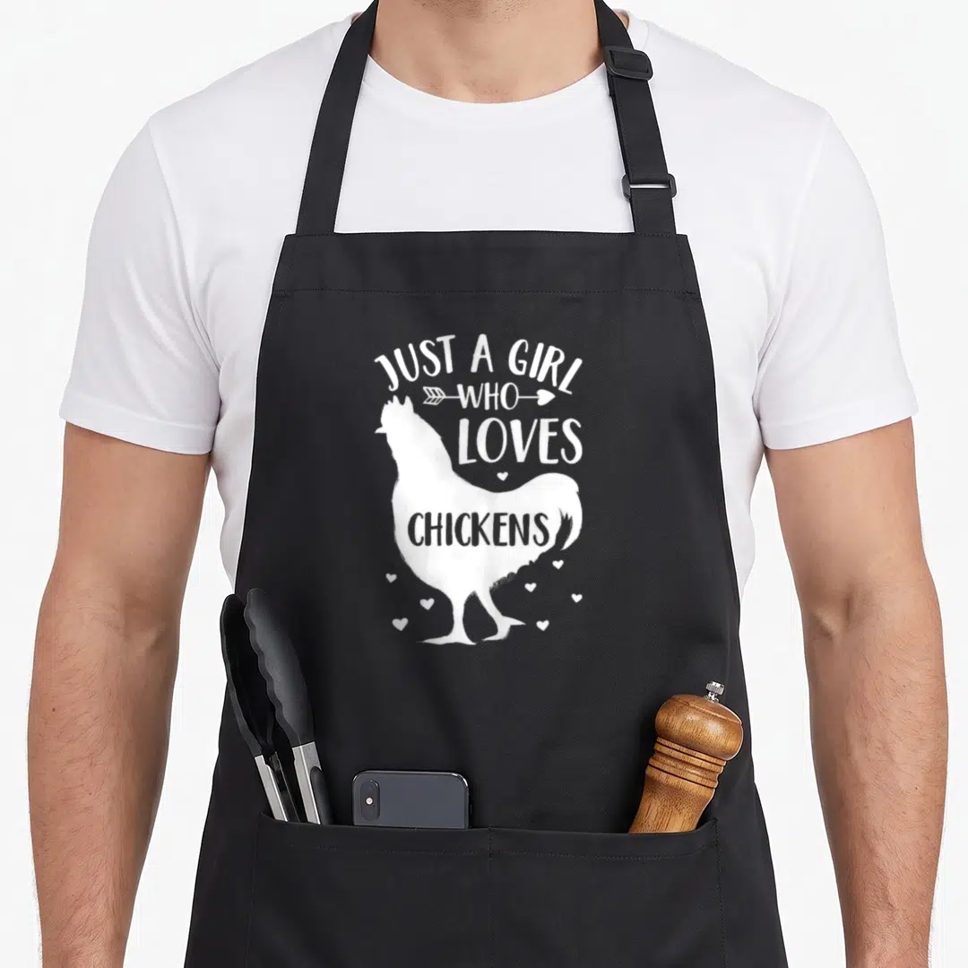 Cute chicken farmer apron - White chicken silhouette with Just A Girl Who Loves Chickens text and small hearts — shown on a black cotton canvas apron against a white background