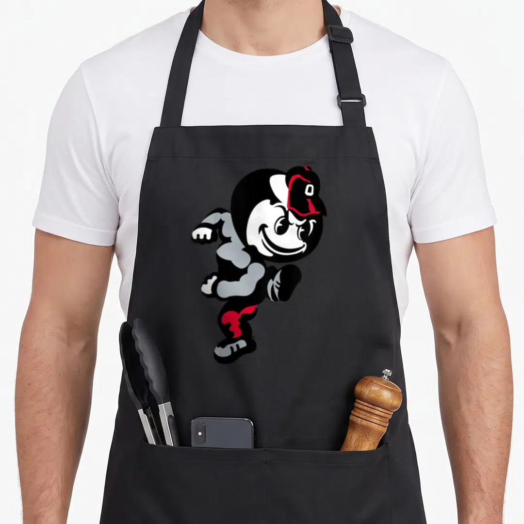 Funny brutus ohio girl apron - Running cartoon mascot in black white grey and red with cap — shown on a black cotton canvas apron against a white background
