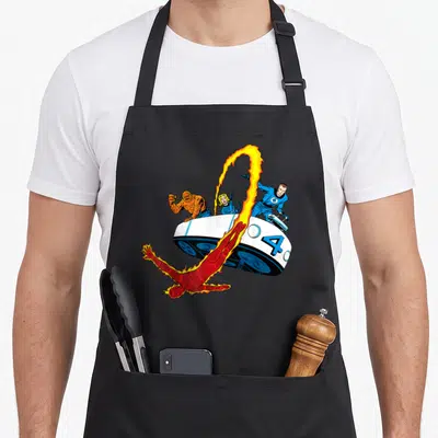 Fantastic fourth apron - Cartoon superhero team on white spaceship with blue four and flaming character flying below — shown on a black cotton canvas apron against a white background
