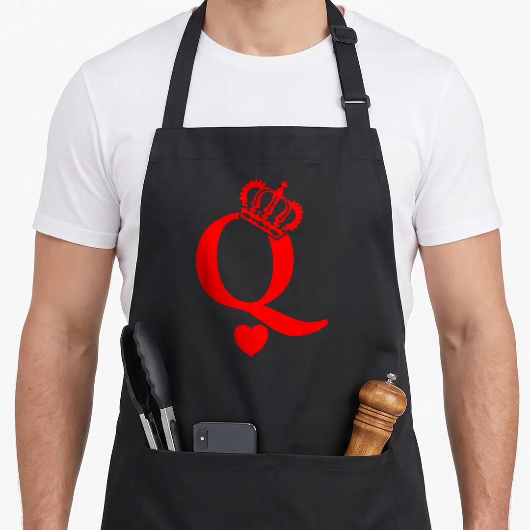 Queen king apron - Red letter Q with crown on top and heart below tail — shown on a black cotton canvas apron against a white background