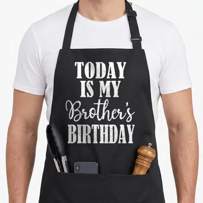 Today family aprons - White stacked text reading Today Is My Brother's Birthday in block and script fonts — shown on a black cotton canvas apron against a white background
