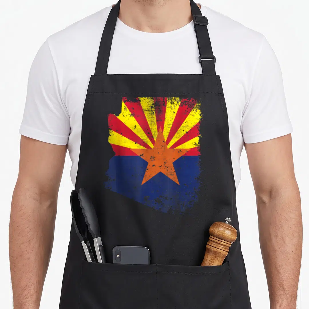 Arizona nofo co apron - Distressed Arizona state map shape filled with orange star and red yellow rays on blue — shown on a black cotton canvas apron against a white background